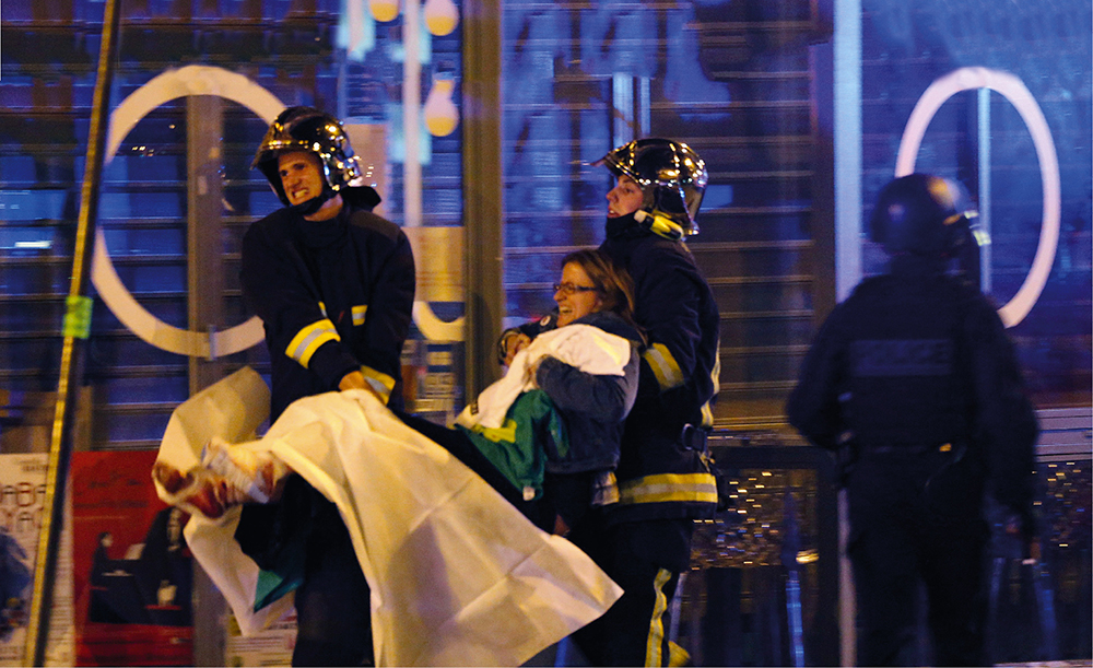 French firefighters carry a wounded woman to safety outside the Bataclan - photo 3