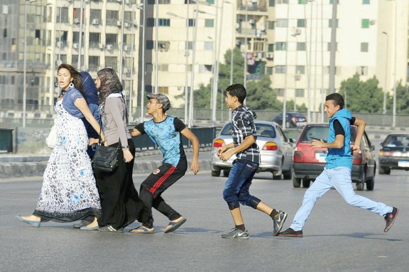 An Egyptian youth grabs a woman crossing the street with her friends in Cairo - photo 4