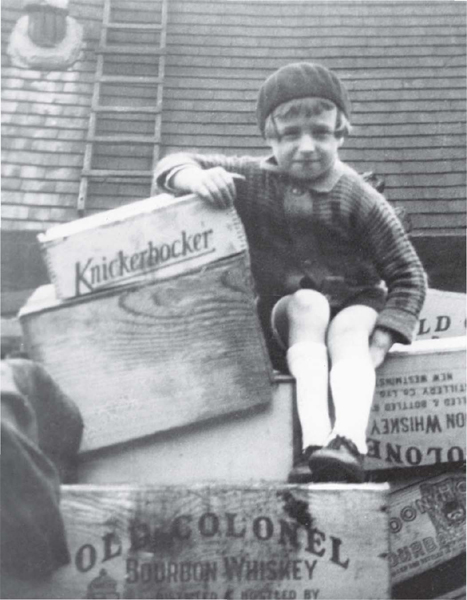 A young boy on the islands of St Pierre and Miquelon perches on liquor crates - photo 2