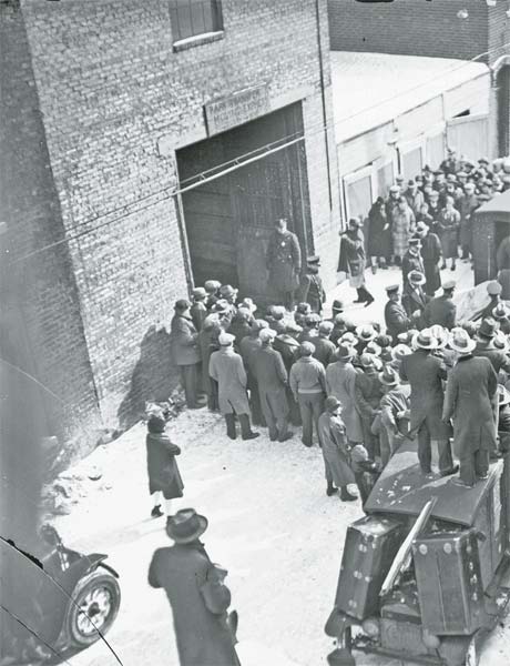 A crowd gathers outside the Clark Street garage as officials remove the victims - photo 4