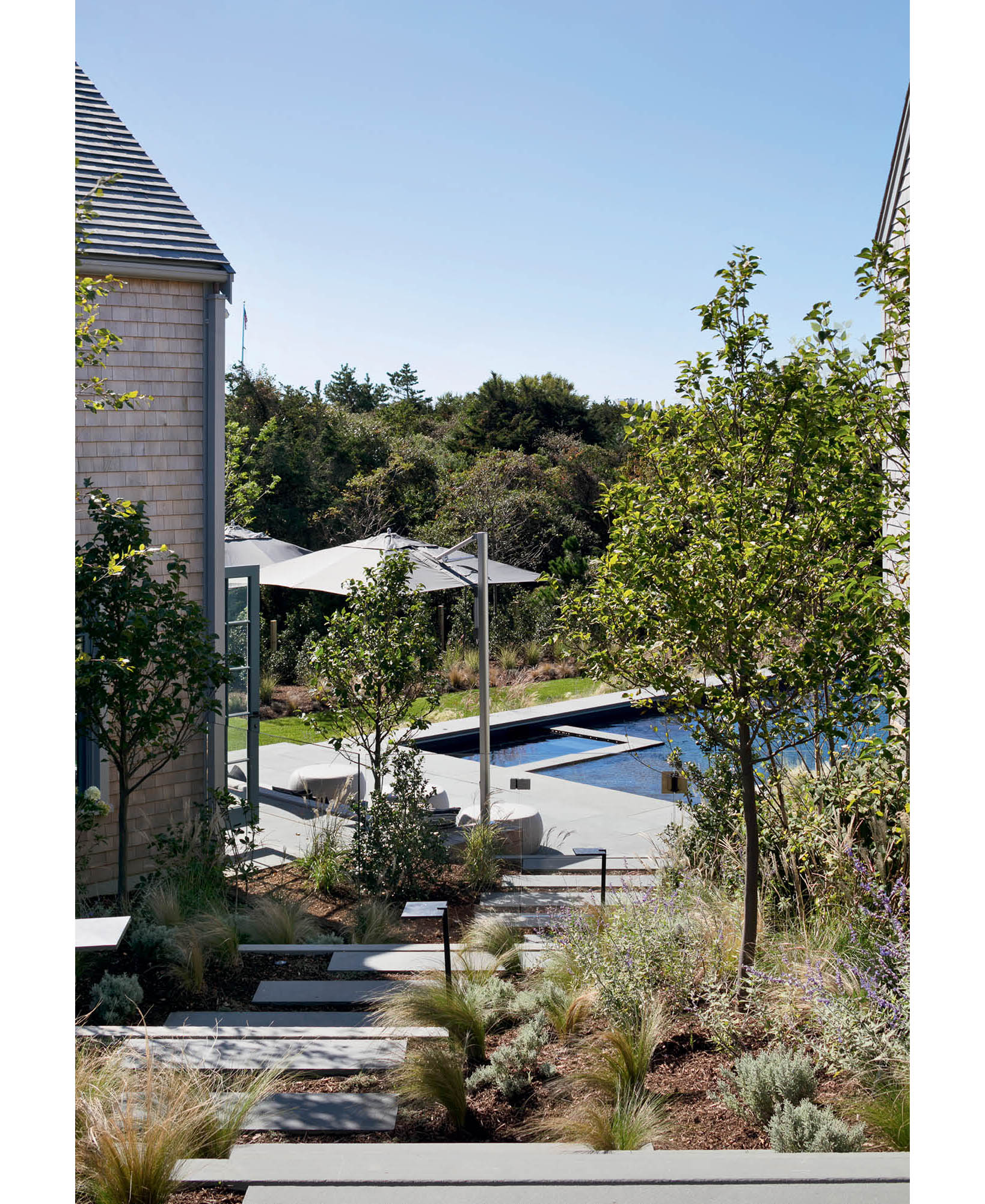 Steps lead down the sloped pathway to the pool area of this Nantucketretreat - photo 8