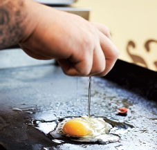 Cooking an egg on the flat top Putting a slice of cheese on top of the ham - photo 9