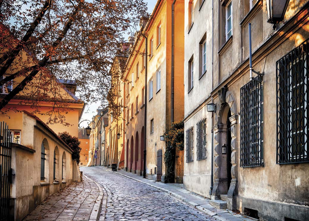 Old buildings line a cobblestone street in the Old Town part of Warsaw which - photo 3