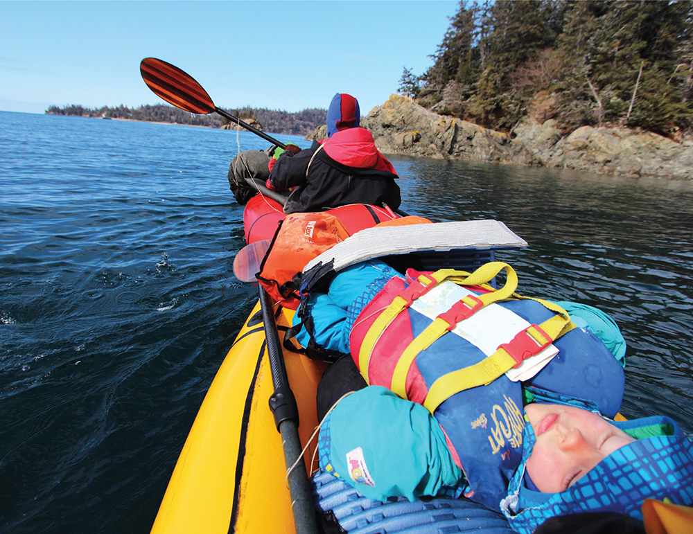 Katmai sleeps on Higs lap while I paddle in front of the rafts lashed together - photo 17