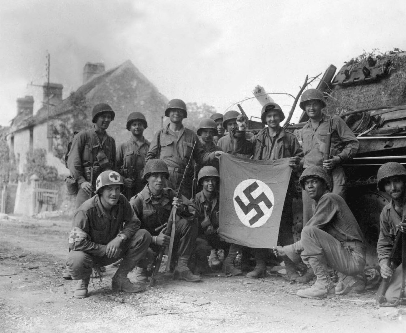 US infantrymen pose with the flag of the defeated occupying Nazi regime in a - photo 5