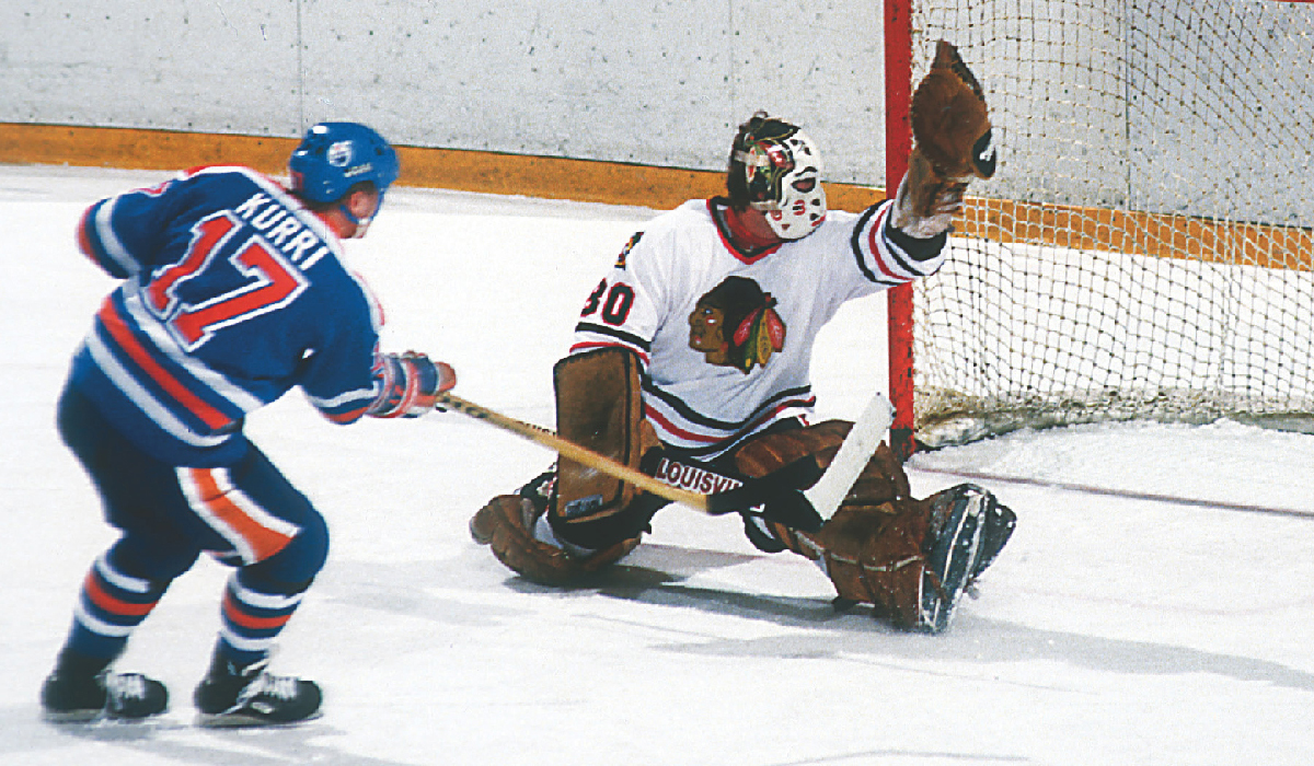 Both Jari Kurri of the Oilers and Murray Bannerman of the Hawks look to see - photo 7