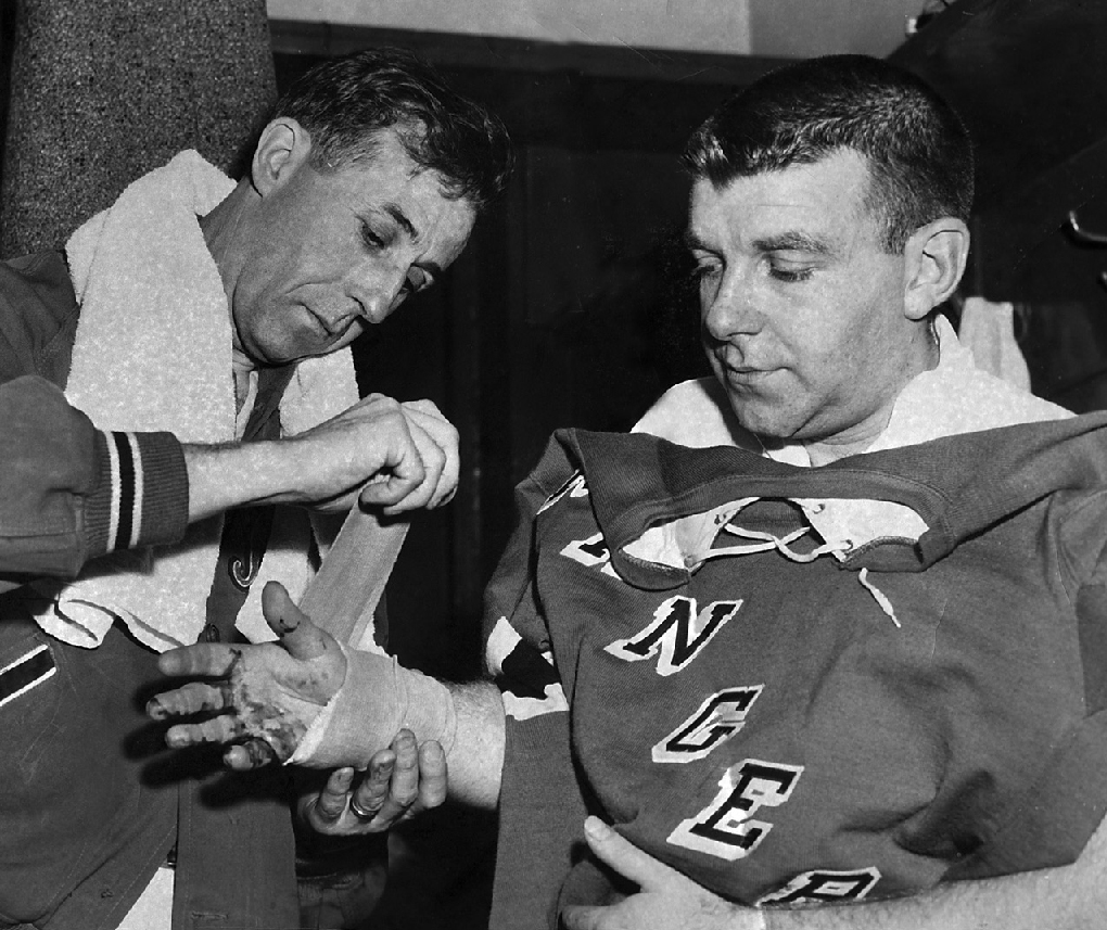 Gump Worsley gets treated by trainer Frank Pace for severed tendons in his hand - photo 4