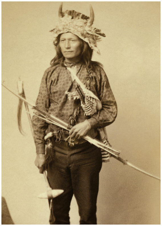 This Oglala man is wearing a horned headdress and holding a bow arrows and a - photo 6