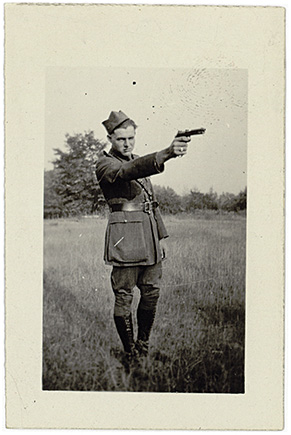 Ernest Hemingway in field wearing uniform and pointing gun undated but circa - photo 3