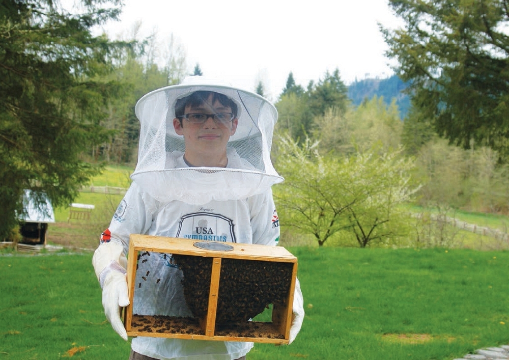 Young beekeeper and entrepreneur Henry Miller shows off some of his bees while - photo 3