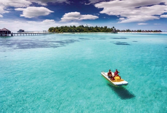 A couple on a pedal boat enjoy the turquoise waters of the Maldives For one - photo 4