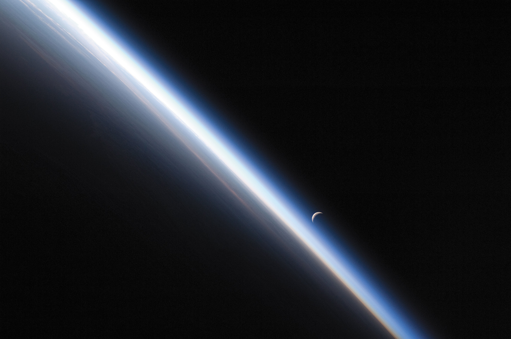 A crescent moon sets behind the thin blue line of Earths On August 27 - photo 5