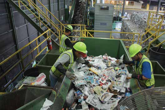 Workers pull plastic from almost-sorted paper at Waste Managements Houston - photo 8