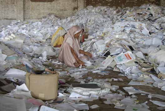 A worker at the Rama Paper Mills outside of Delhi India separates cardboard - photo 15