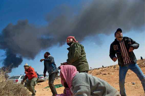 Rebel fighters and drivers look up into the sky in anticipation of a bomb and - photo 7