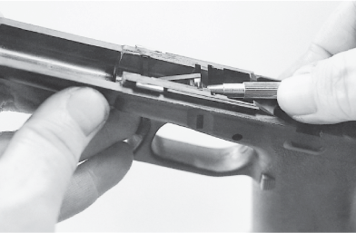 Insert a tool into the magazine well to tip the upper end of the magazine catch - photo 25