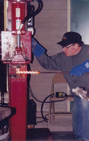 The author flattens an accordion-style damascus bar on a hydraulic press - photo 3