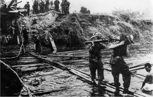 Viet Minh guerrillas cross an improvised bridge during their struggle against - photo 6