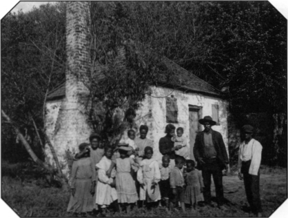 A family of African Americans outside former slave quarters in the early - photo 8