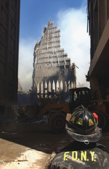 A New York City fire fighter looks up at what remains of the World Trade Center - photo 2