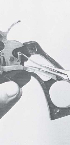 Grip the mainspring with smooth-jawed sharp-nosed pliers and compress it - photo 12