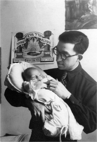 14 Zvi Silberman holds his newborn son in a DP camp in Austria The sign behind - photo 18