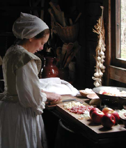 By window light an interpreter in period costume prepares vegetables and - photo 9