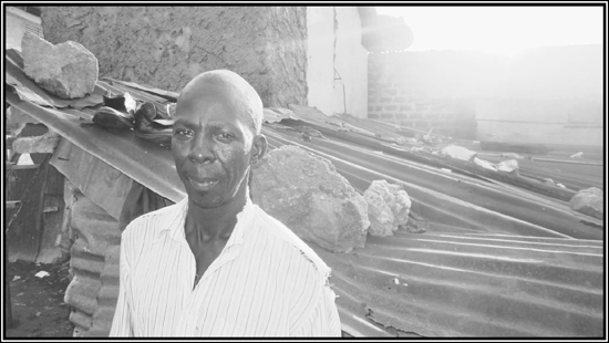 Hakim Ssewaya who has lived 40 years in Katwe stands in front of his shack - photo 1