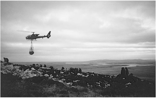 A British helicopter ferrying equipment via underslung netting Both sides - photo 2