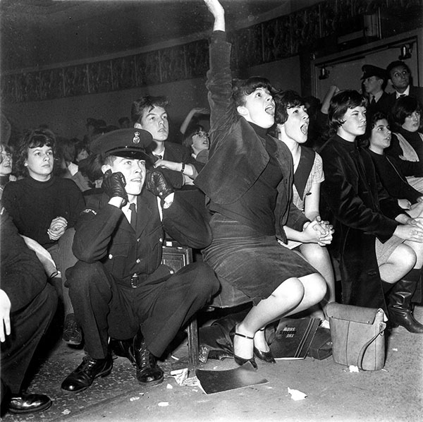 Screaming Beatles fans in Manchester England force a young police cadet to - photo 3