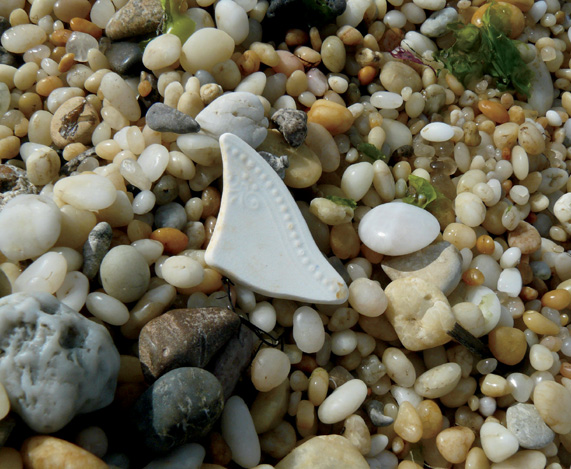 The triangular shape of this pottery shard stands out among the rounded stones - photo 2