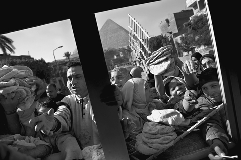 Egyptians mob a kiosk selling government-subsidized bread near the Great - photo 3